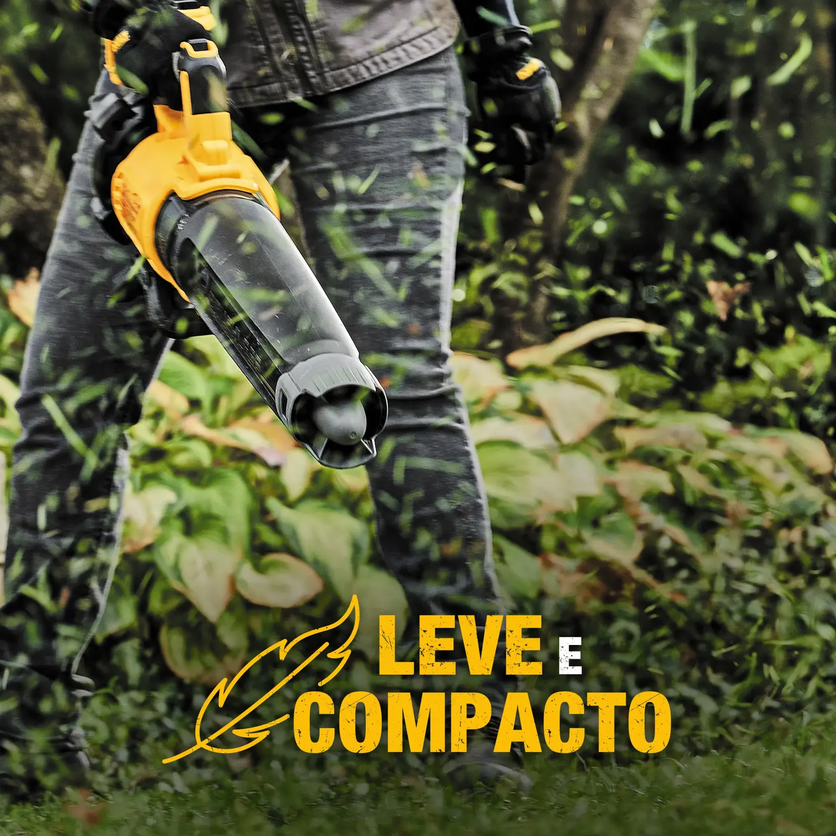 Uma pessoa utiliza um soprador de folhas sem fio DEWALT amarelo e preto para limpar folhas ou detritos ao ar livre perto de um muro de pedra e cercas vivas.
