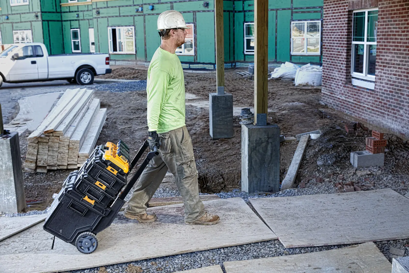 Vista frontal de un cargador de batería DEWALT DCB104 amarillo y negro de cuatro puertos con asa, diseñado para cargar varias baterías de herramientas eléctricas al mismo tiempo.
