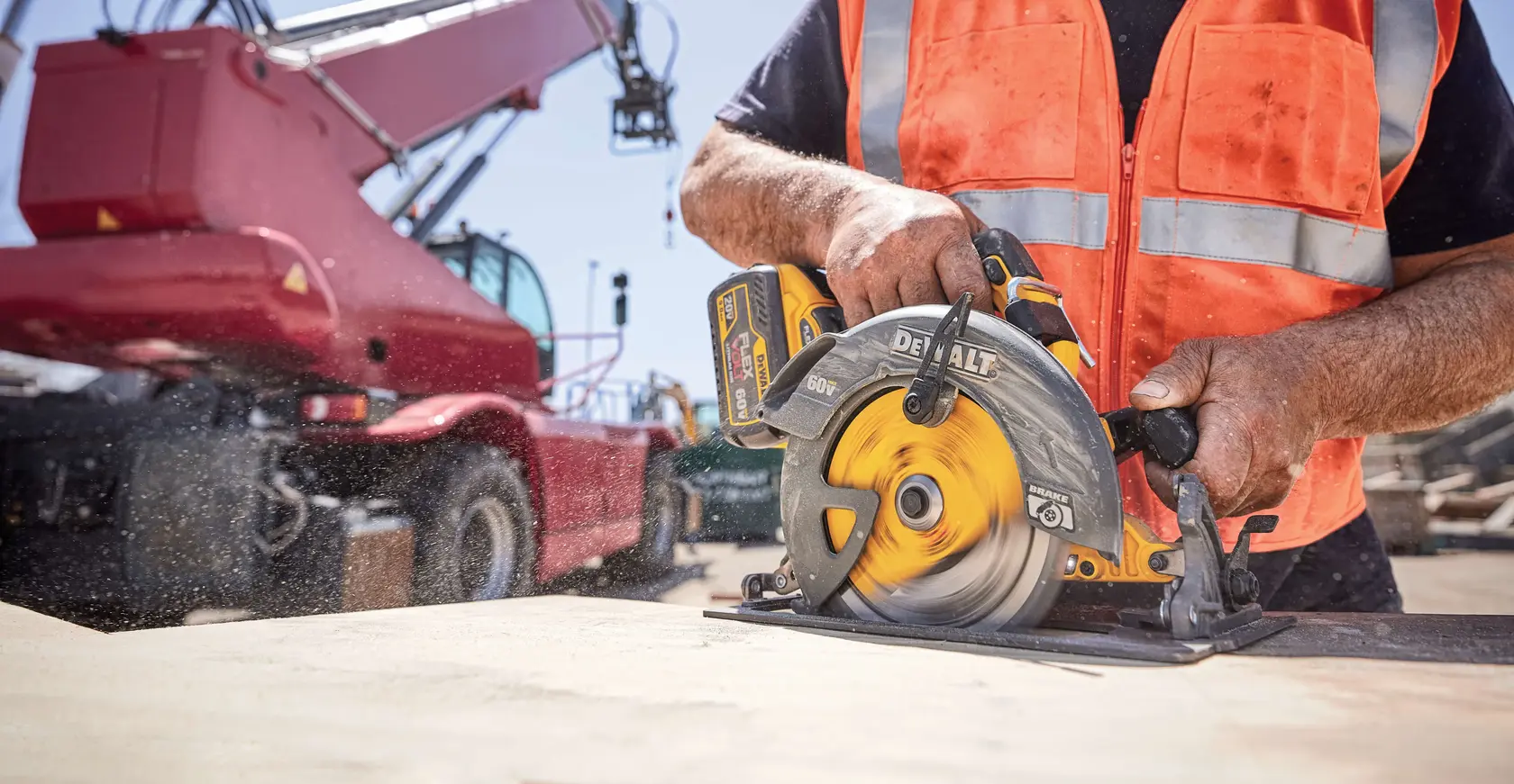Foto da serra circular sem fio DEWALT DCB609 cortando madeira em obra, operada por trabalhador com colete laranja.