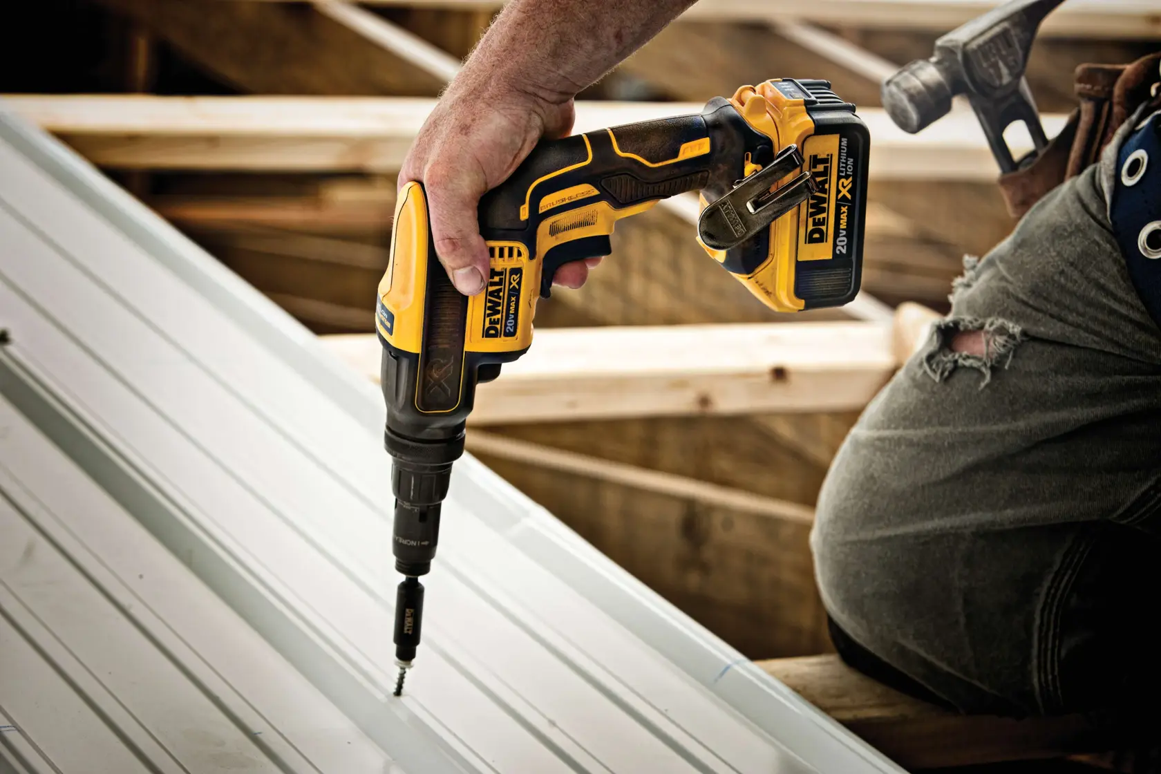 Vista de perto de uma ferramenta elétrica DEWALT 20V MAX XR com motor brushless sendo usada para parafusar em uma superfície metálica. A imagem inclui o texto 'Apenas ferramenta. Eficiência e maior tempo de funcionamento com motor brushless.'