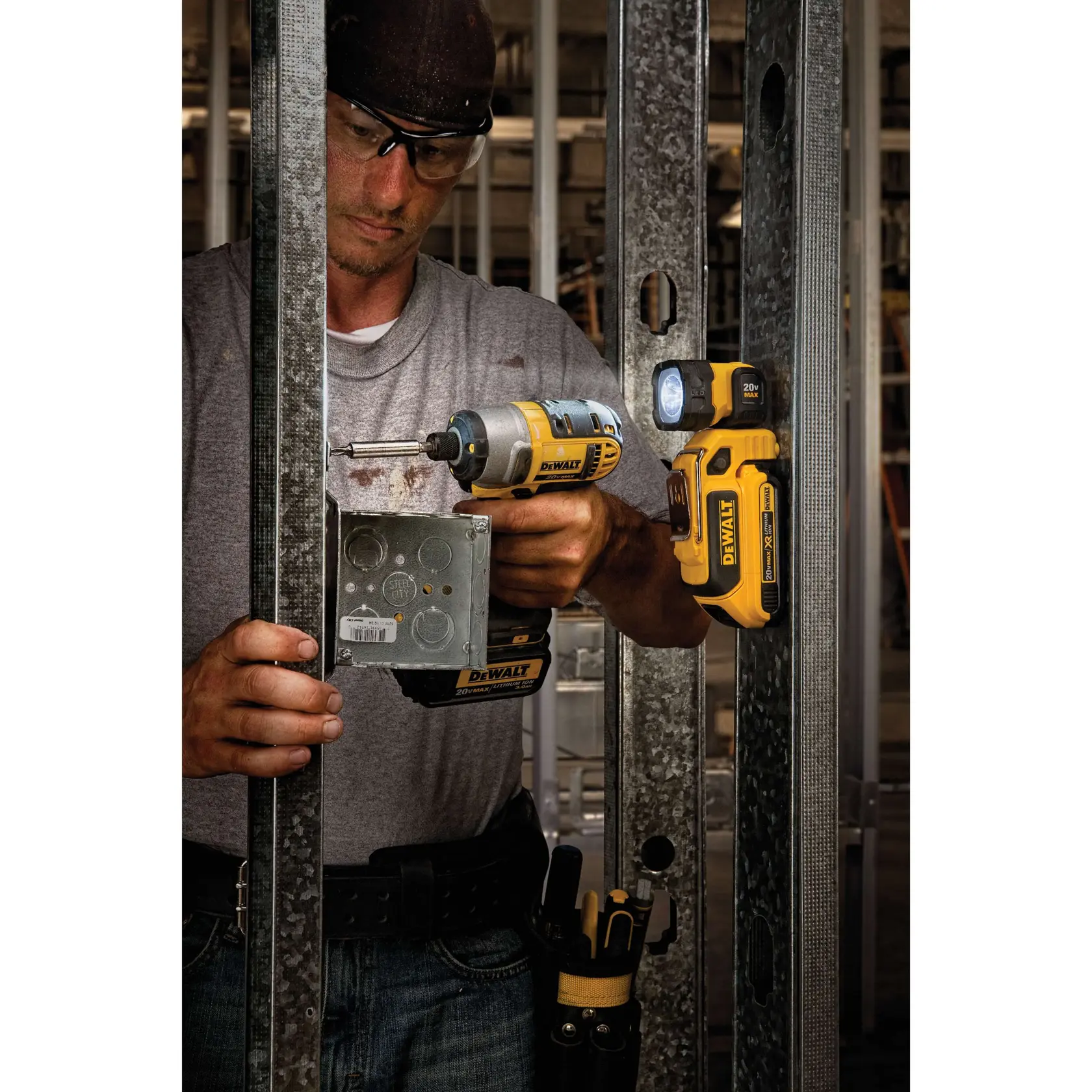 Foto da luz de trabalho DEWALT DCL044 presa no suporte metálico, iluminando área de serviço.