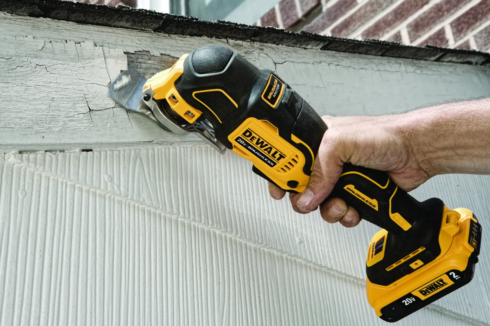 Uma multiferramenta oscilante brushless DEWALT 20V em uso, mostrada cortando uma seção de acabamento perto de uma janela. O texto na imagem diz: 'Controle total com gatilho de velocidade variável.'