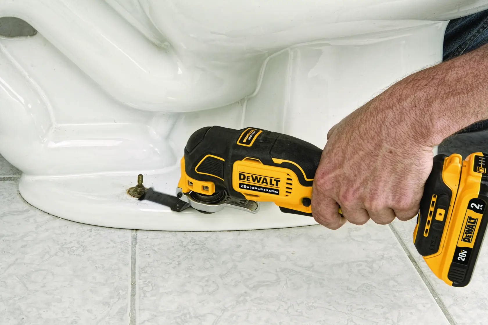 Uma mão usando uma ferramenta oscilante DEWALT 20V sem escova para cortar ou remover um parafuso próximo à base de um objeto branco, com o texto 'Extended Runtime with Brushless Motor' exibido abaixo.