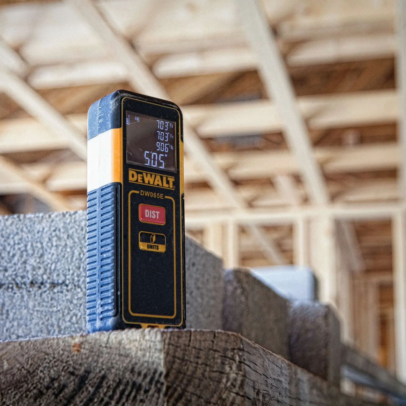 Um medidor de distância a laser DEWALT DW065E, mostrando as principais características. O aparelho possui uma tela digital com medições, botões 'DIST' e 'UNITS', e exterior durável moldado. Mede até 65 pés com precisão de +/- 1/8 polegada a 33 pés, calcula área e volume, mede em pés, polegadas e metros, e utiliza pilhas AAA.