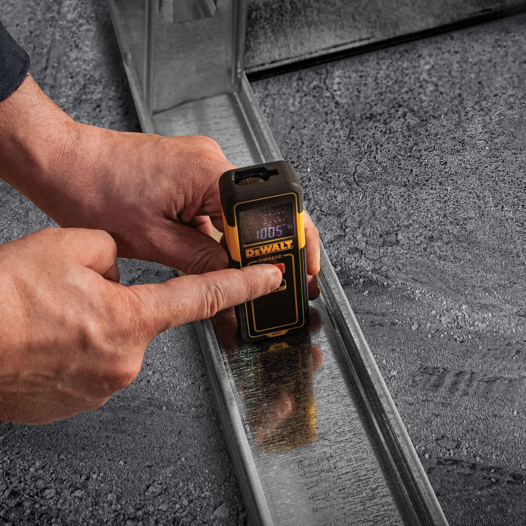 Gráfico mostrando um dispositivo DEWALT DW065E com destaque para o recurso de sobre-molde para durabilidade, exibido em um fundo amarelo com texto preto em negrito afirmando 'SOBREMOLDE PARA DURABILIDADE.'