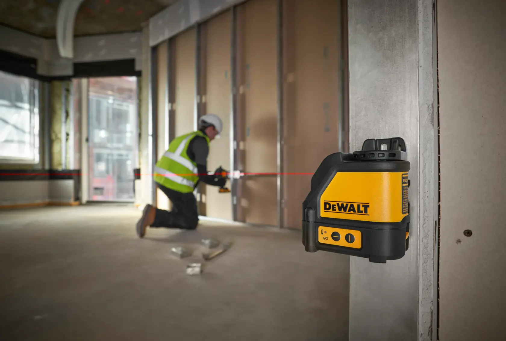 Nível a laser de linhas cruzadas DEWALT DW088K em um estojo resistente com sobre-moldagem. As características mostradas nas etiquetas incluem: precisão de ±1/8 polegada a 30 pés, feixe vermelho, proteção IP54 contra poeira e água, aceita pilhas alcalinas, alcance de 100 pés (165 pés com detector, detector vendido separadamente).