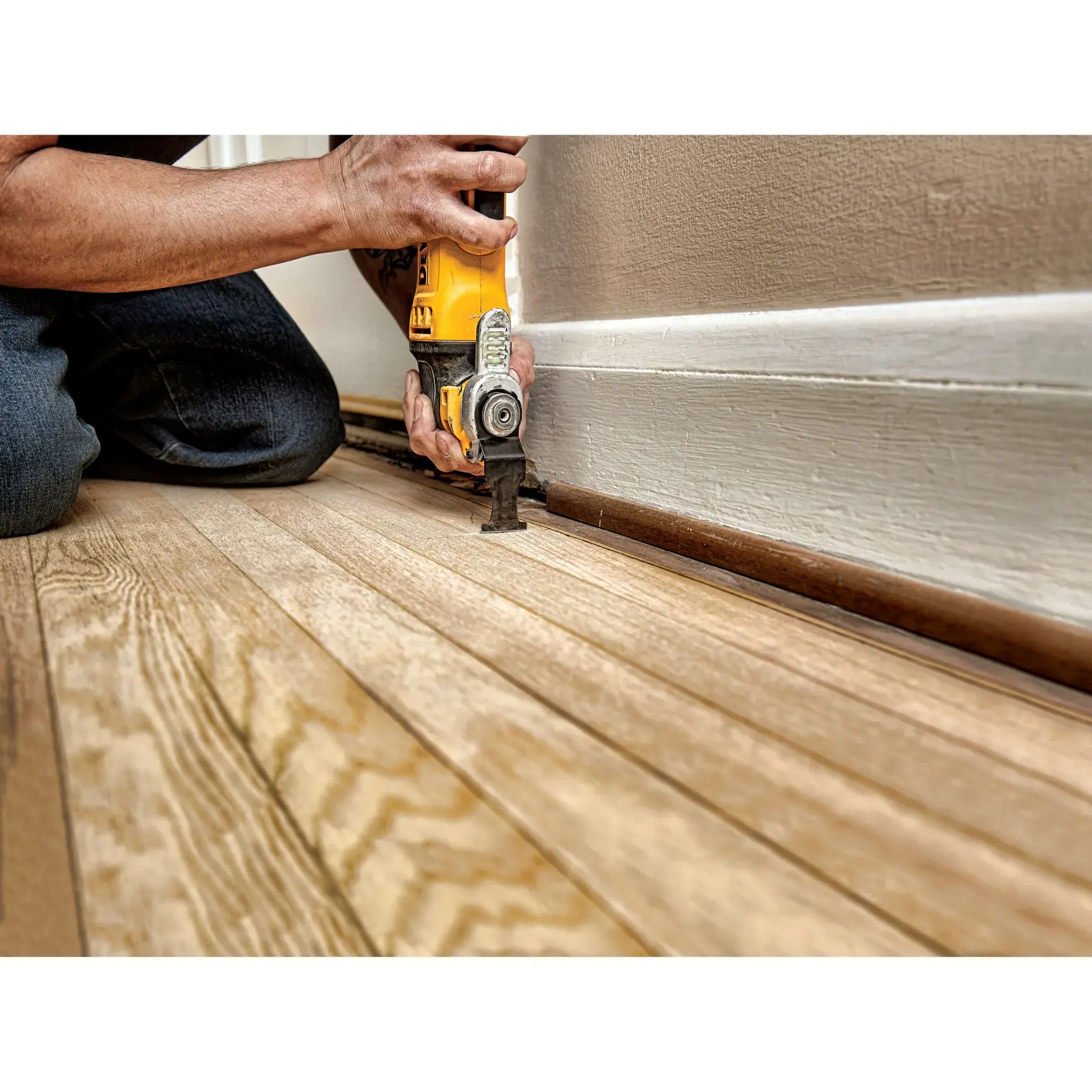 Imagem em close de uma ferramenta oscilante DEWALT cortando gesso perto de parafusos, com um grande gráfico promocional no centro que diz '2X A VIDA DA LÂMINA FEIN*'. Abaixo, há um aviso sobre a comparação da lâmina oscilante com borda de carbeto DEWALT Elite Series com lâminas de carbeto FEIN.