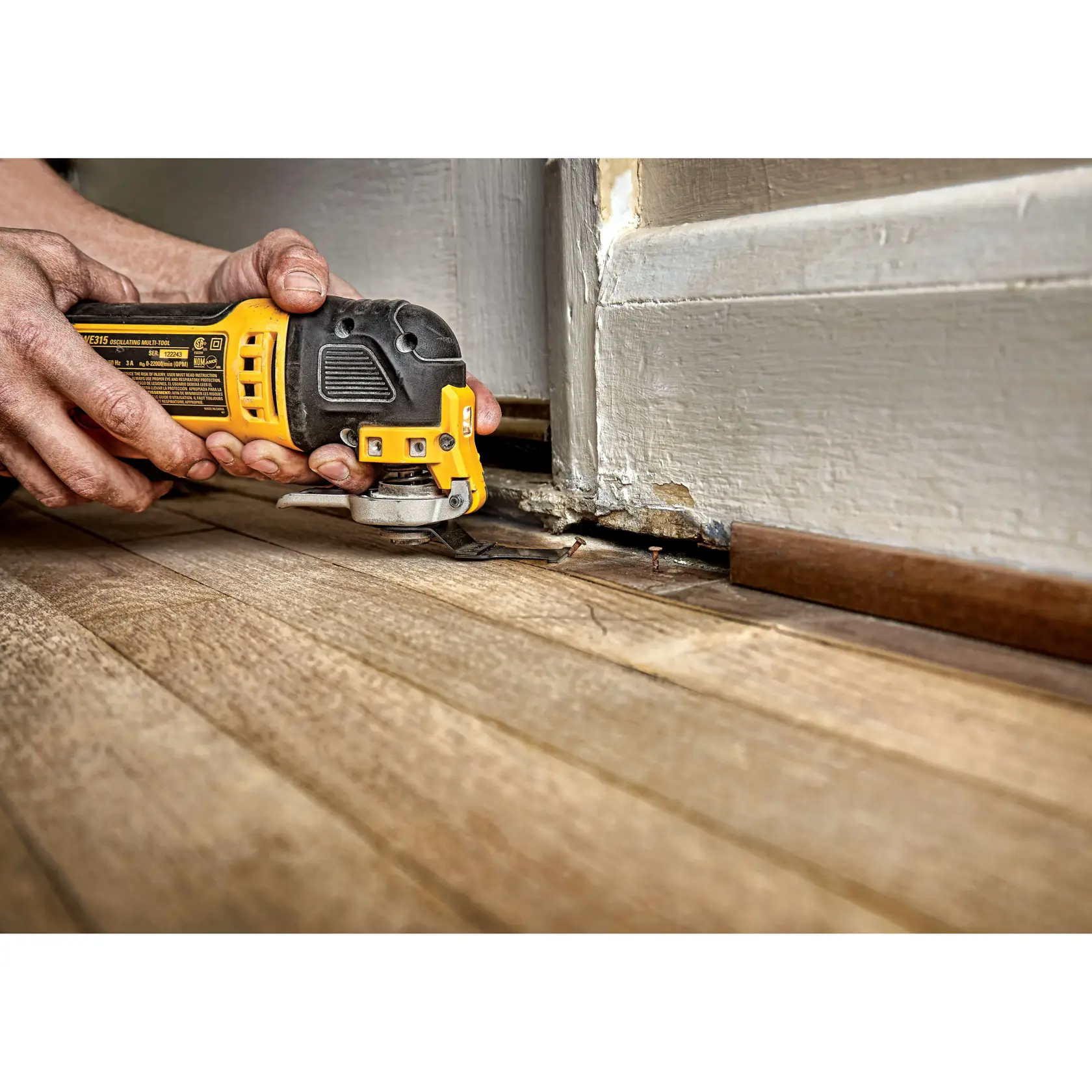 Imagem de uma lâmina de ferramenta oscilante DEWALT com borda de carbeto, identificada como lâmina de demolição de 1-1/4 polegadas, projetada para cortar materiais duros. A imagem inclui ilustrações de materiais como aço, madeira com pregos, drywall e parafusos. O texto diz: 'Borda de carbeto para longa vida útil em materiais duros.'