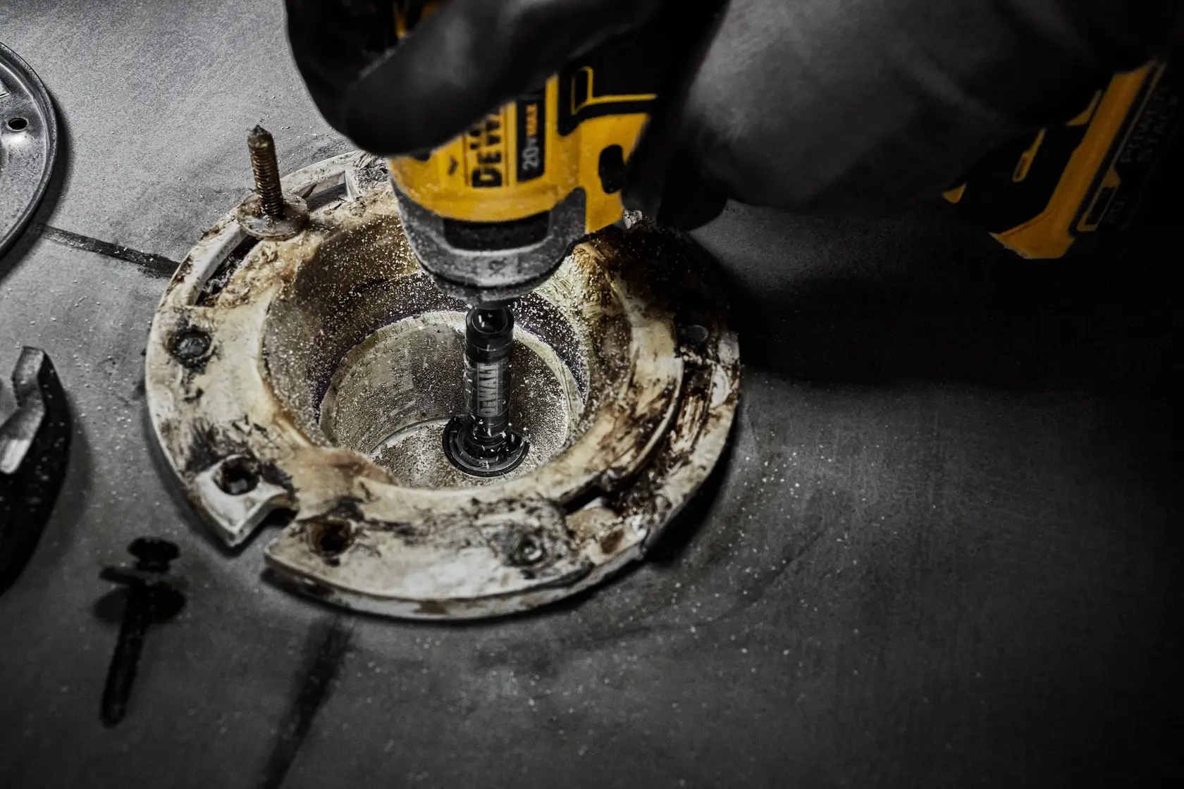 Um driver de impacto da DEWALT está cortando concreto com uma ferramenta cilíndrica. A imagem destaca o texto em negrito '2X FASTER CUTS', promovendo o potencial máximo de velocidade de corte.