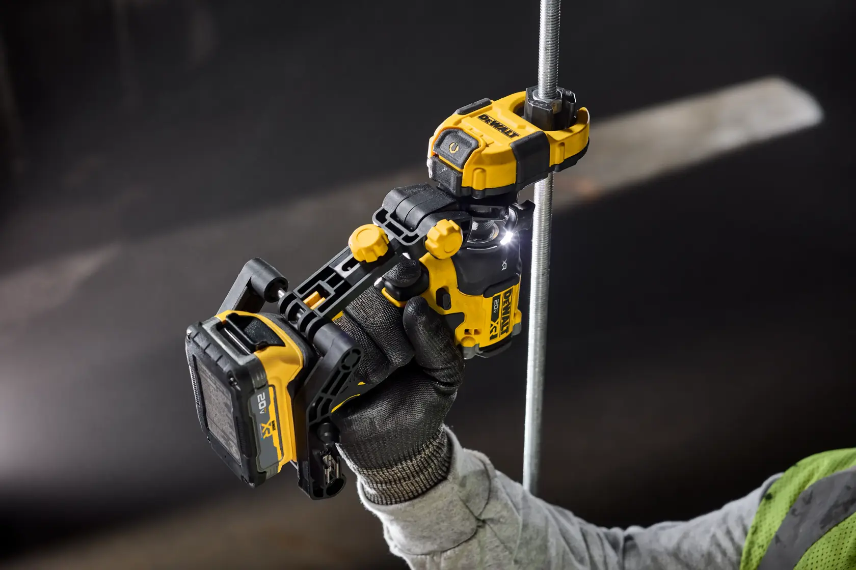 Um acessório de ferramenta elétrica DEWALT sendo utilizado com um parafusadeira de impacto DEWALT para colocar uma porca em uma haste roscada. O usuário está usando luvas e a imagem destaca que a parafusadeira de impacto é vendida separadamente. O texto indica que o acessório é três vezes mais rápido do que apertar porcas manualmente.