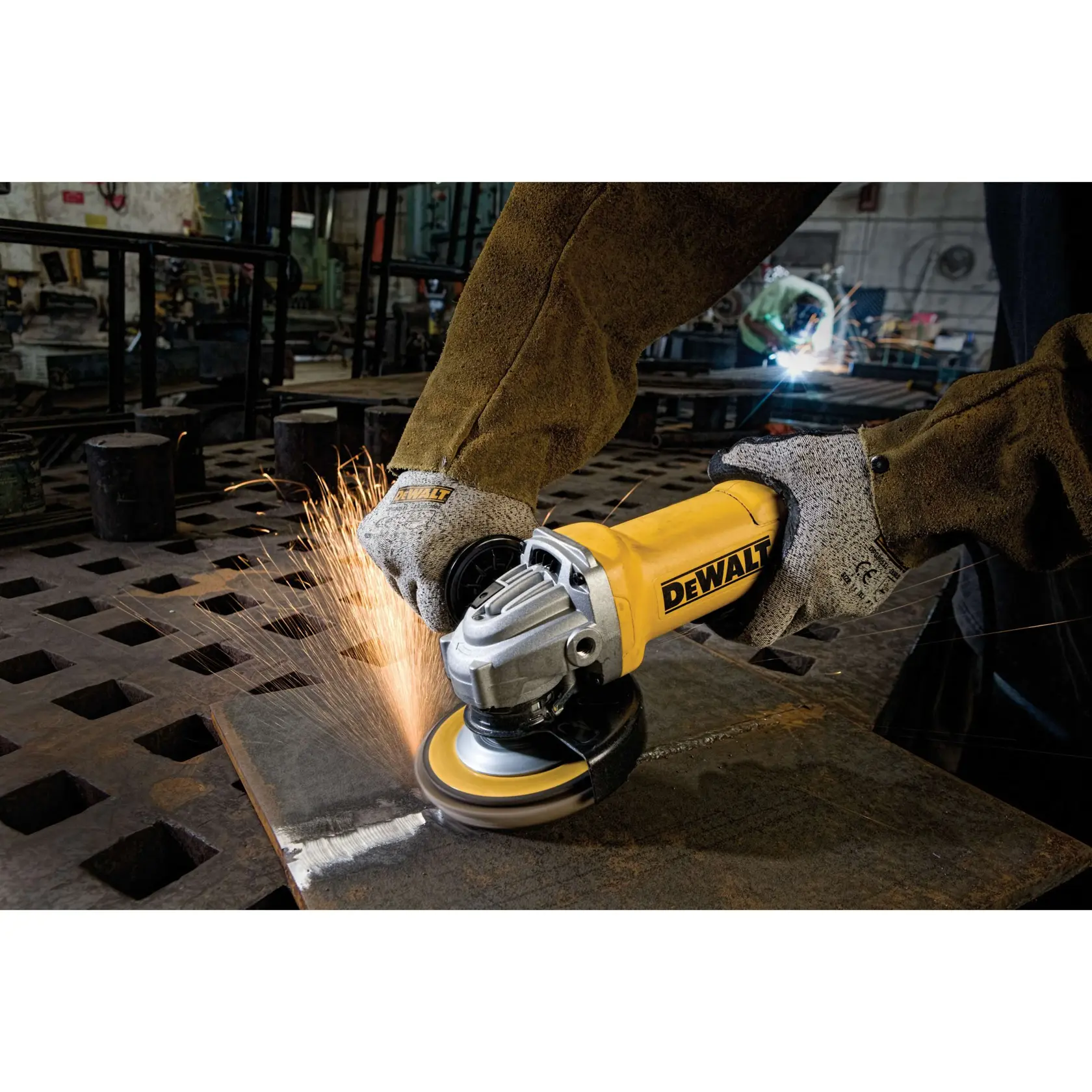 Uma pessoa usando luvas de segurança e jaqueta protetora opera uma esmerilhadeira angular DEWALT para cortar ou desbastar um pedaço de metal, com faíscas sendo produzidas em uma oficina industrial.