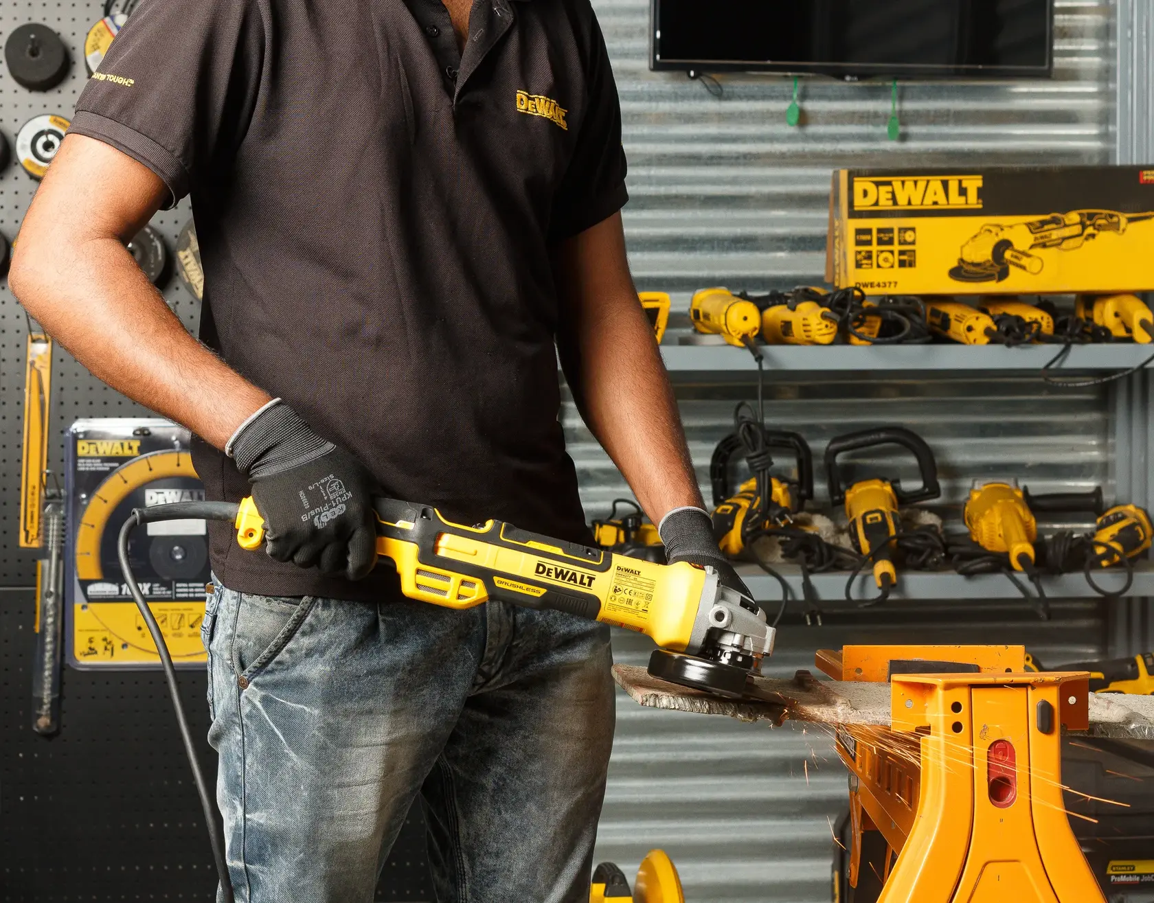 Foto de pessoa usando esmerilhadeira DEWALT DWE4377 na oficina, faíscas ao cortar metal.