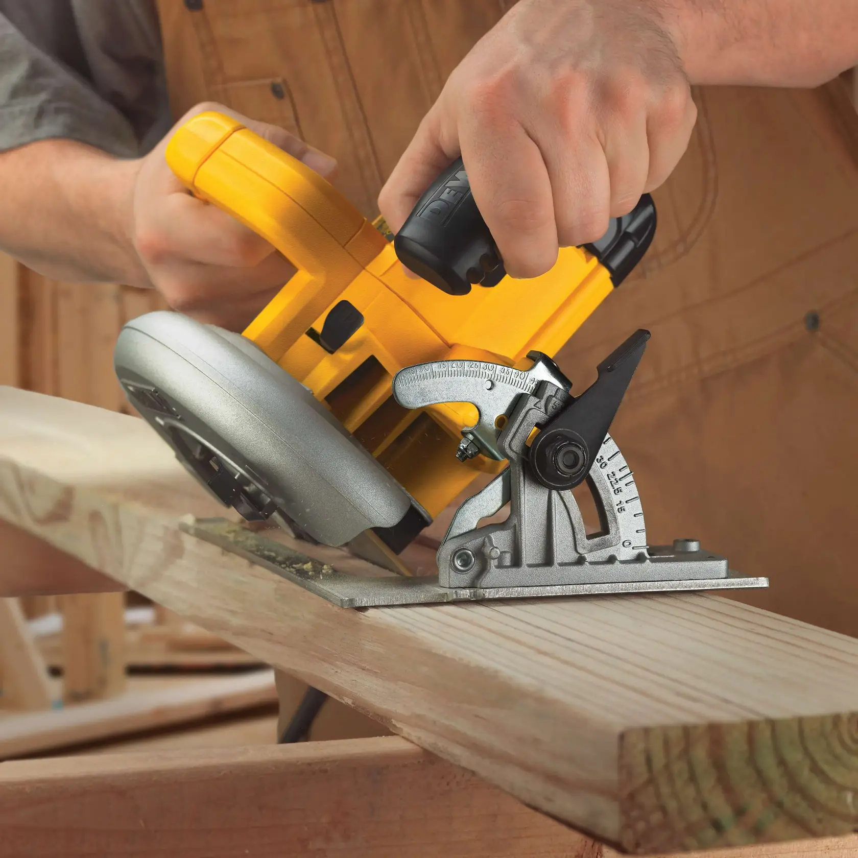 Uma pessoa utiliza uma serra circular amarela DEWALT DWE575 para cortar um pedaço de madeira em ângulo. A placa de base e o mecanismo de ajuste de ângulo da serra estão visíveis, e a pessoa está usando um avental de trabalho marrom.