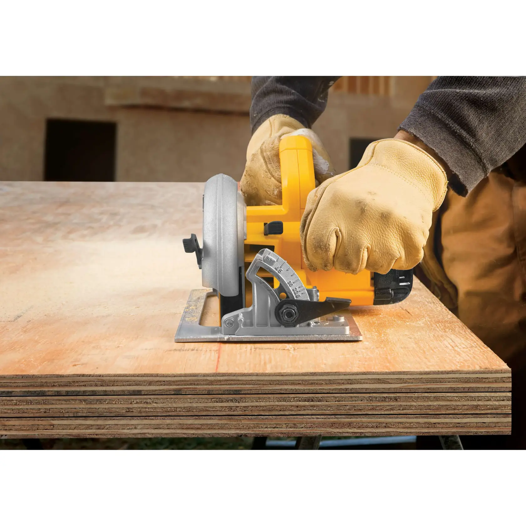 Uma pessoa usando luvas de trabalho está utilizando uma serra circular amarela DEWALT DWE575 para cortar folhas de madeira compensada.
