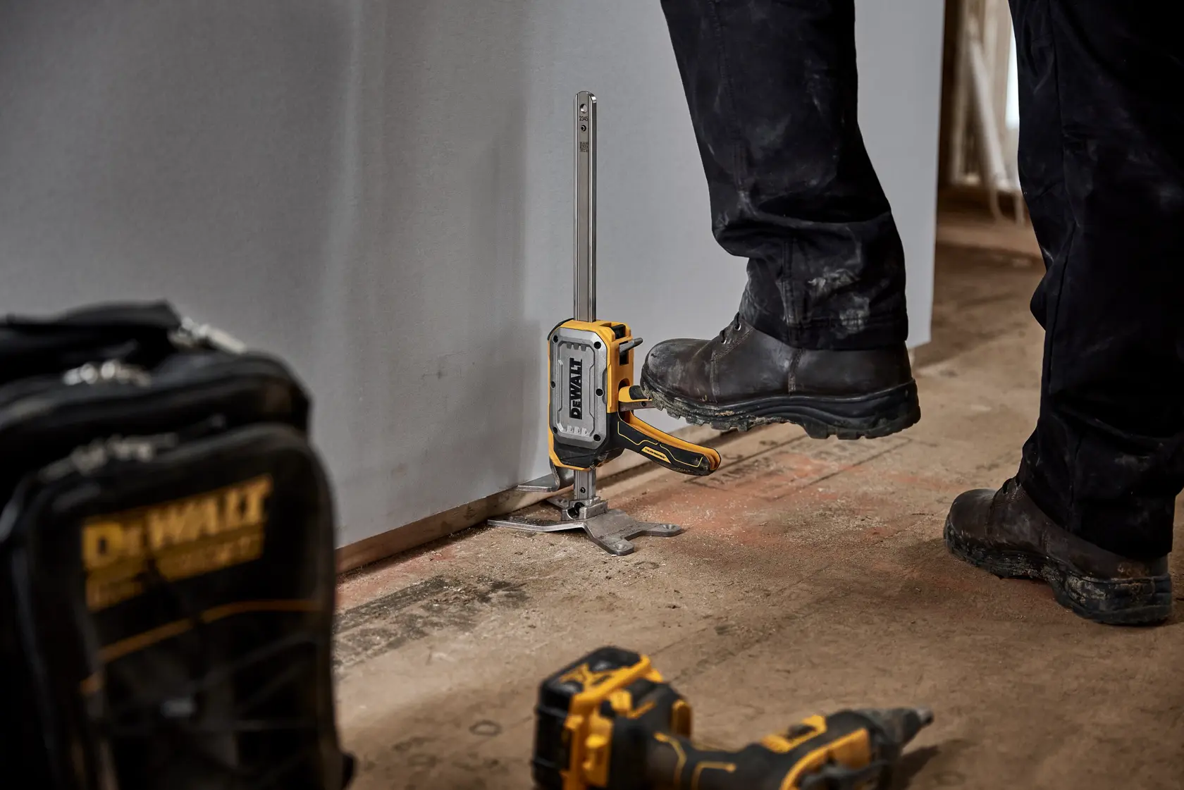 Imagen del gato de construcción ToughSeries DEWALT con componentes etiquetados: botón de liberación rápida sin carga, lengüeta de descenso controlada con precisión, palanca de elevación manos libres, puntos de anclaje a ras, acceso bajo la aplicación y capacidad de elevación hasta 340 lbs. El producto está colocado sobre una superficie plana con varias características resaltadas.