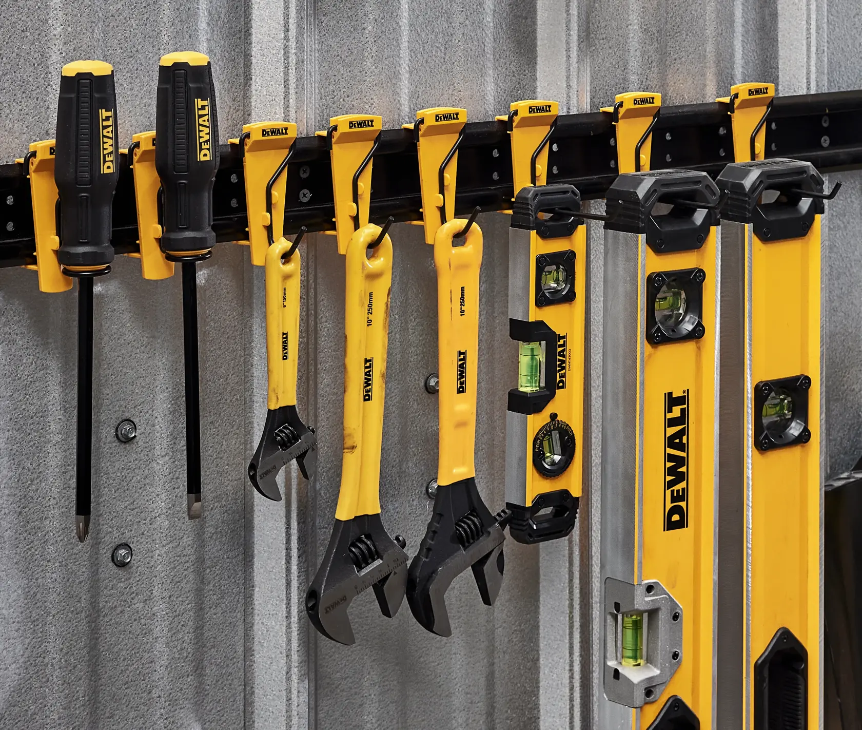 Imagem do sistema de armazenamento personalizável para oficina DEWALT, apresentando oito ganchos ou suportes de metal amarelos e pretos para organizar ferramentas e equipamentos. A marca DEWALT está visível em cada gancho, e o banner superior diz 'Customizable Workshop Storage System.'
